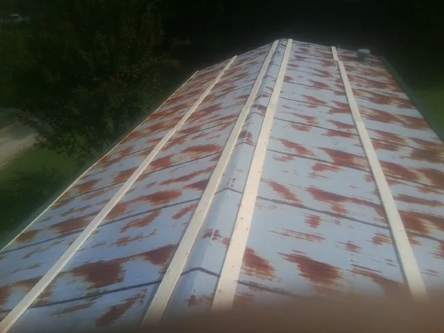 Rusted metal roof panels with new wood purlins before replacement — Storm Damage Roof Repair in Friendswood by Roofing Brothers
