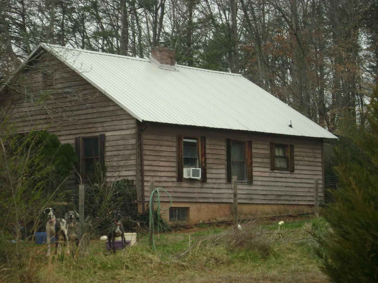 White metal roof on an old wood sided farmhouse, from a Metal Roof Installation job in Friendswood